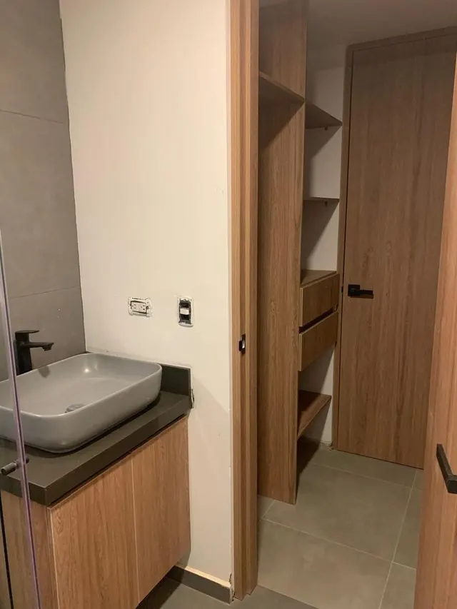 Baño con lavamanos suspendido y vestier con cajones y repisas