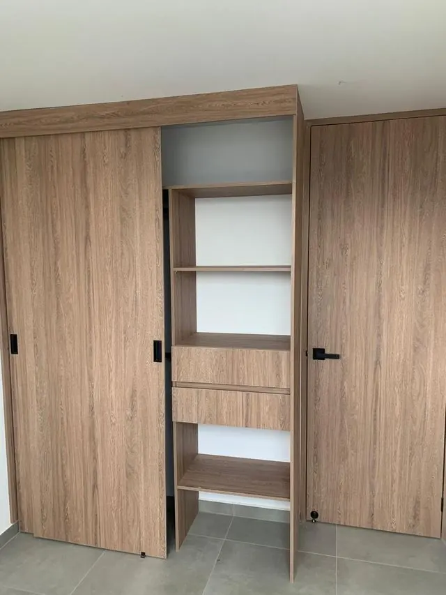 Closet con puerta corrediza, cajones y entrepaños en madera