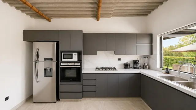 Cocina terminada en L con nevera, horno empotrado y mesón blanco tipo mármol