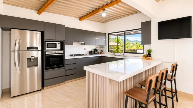 Cocina en U con barra de listones de madera y butacas