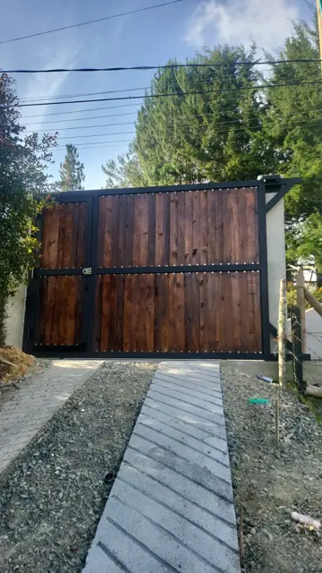 Portón corredizo en hierro y madera con puerta peatonal